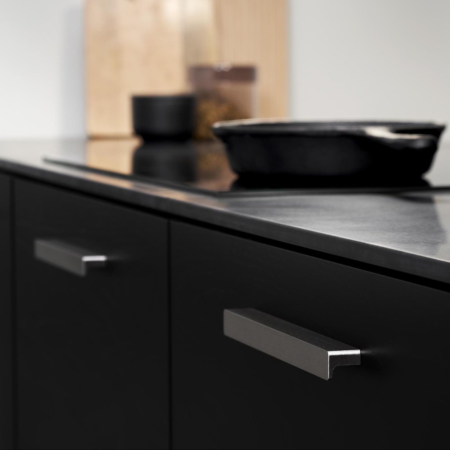 May include: A set of three ceramic mugs with a speckled, cream-coloured glaze. Each mug features a different hand-painted design: a blue and green leaf, a yellow flower, and a red berry. The mugs have a simple, modern design.